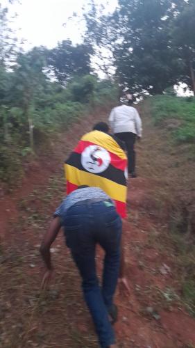 a group of people walking down a dirt path at Jusvero Motel in Jinja