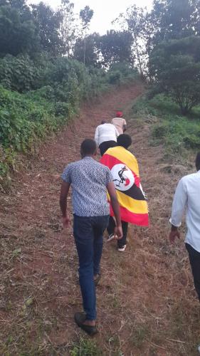 a group of people walking down a dirt road at Jusvero Motel in Jinja
