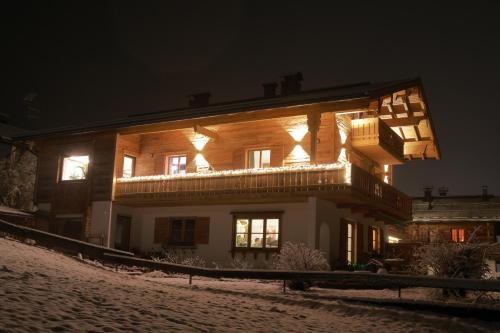 a house with lights on the side of it at night at Bergchalet Four Seasons in Reit im Winkl