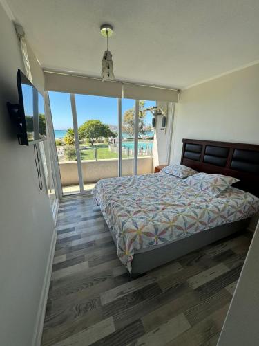 Schlafzimmer mit einem Bett und Meerblick in der Unterkunft Departamento en playa herradura in Coquimbo