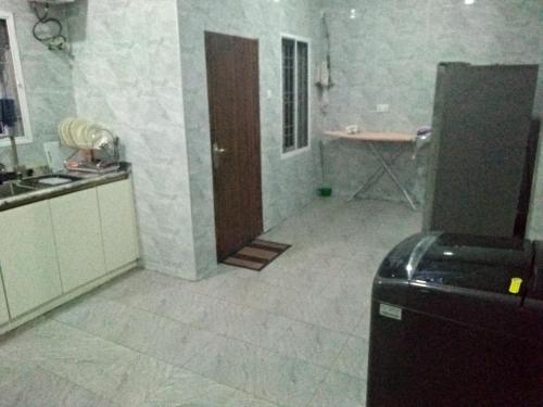 a kitchen with a sink and a refrigerator in a room at CIS SERVICE APARTMENT in Rubuchi