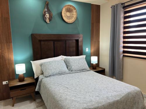 1 dormitorio con 1 cama con pared azul en Urban Hotel El Ancla Suites - Apartment 3 en Puerto Peñasco