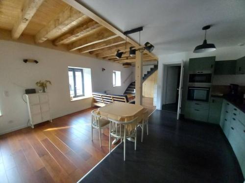 une cuisine et une salle à manger avec une table et des chaises dans l'établissement Le Murger, sud Bourgogne, à Ozenay