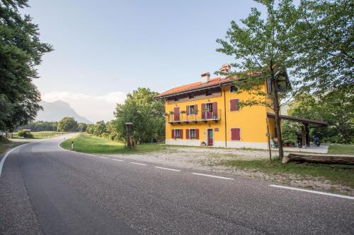 a yellow house on the side of a road at Agriturismo Malga Riondera in Ala