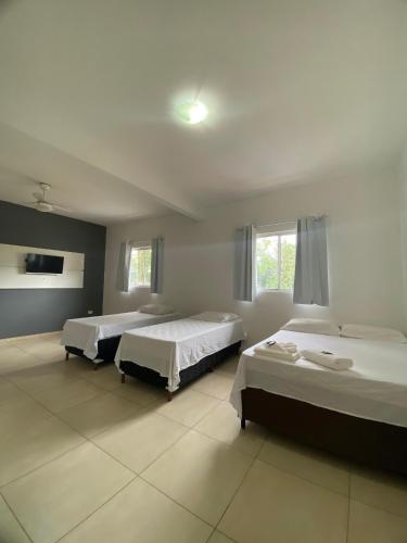 1 dormitorio con 2 camas en una habitación en Recanto Bromélias en Camburi