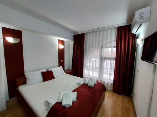 a hotel room with a large bed and a window at The Bulevard Hotel in Skopje