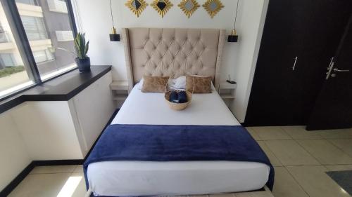 1 dormitorio con 1 cama grande con manta azul en Ecusuites Jacuzzi Bellini Hidromasaje Privado, en Guayaquil