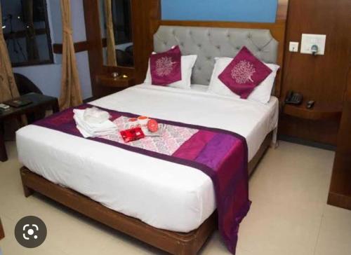 een slaapkamer met een groot bed met rode en paarse kussens bij OYO Hotel sweet Elite in Meerut