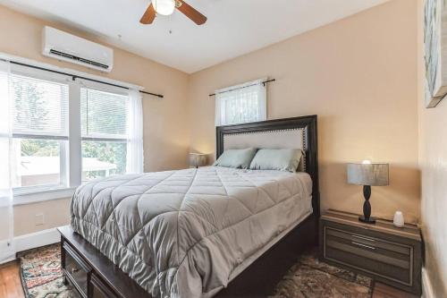 a bedroom with a large bed and two windows at Beautiful Home Steps from the beach + Side Porch in Daytona Beach