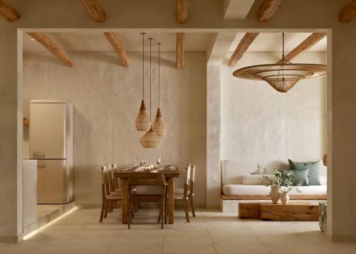 a kitchen and dining room with a table and a refrigerator at Elaia Luxury House in Archangelos