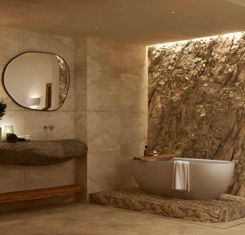 a bathroom with a tub and a sink and a mirror at Elaia Luxury House in Archangelos