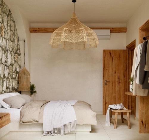 a bedroom with a bed and a chandelier at Elaia Luxury House in Archangelos