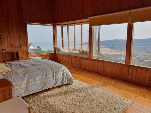 a bedroom with a bed in a room with windows at Tunquén preciosa casa con espectacular piscina in Algarrobo