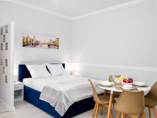 a bedroom with a bed and a table with chairs at Apartament Greta in Złoty Stok