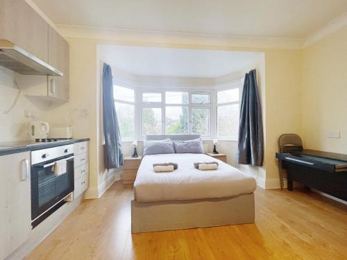 una camera con un letto e una grande finestra di Large Cosy Property 15min from Central London a Londra