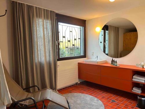 W łazience znajduje się umywalka i lustro. w obiekcie Haus A Ankommen-Abschalten-Auftanken w Bregencji