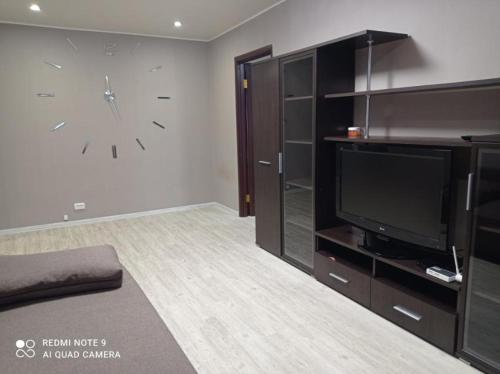 una sala de estar con un reloj grande en la pared en Автовокзал Apartaments 2kv en Dnipró