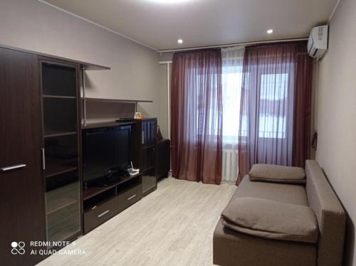een woonkamer met een bank en een flatscreen-tv bij Автовокзал Apartaments 2kv in Dnipro