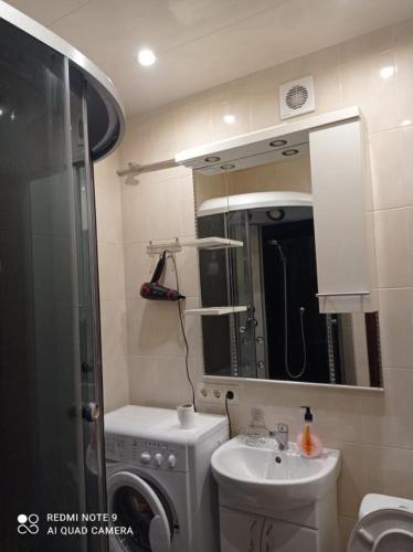 een badkamer met een wastafel en een wasmachine bij Автовокзал Apartaments 2kv in Dnipro