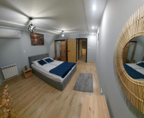 a bedroom with a bed and a mirror at Apartament Słoneczny in Tarnów
