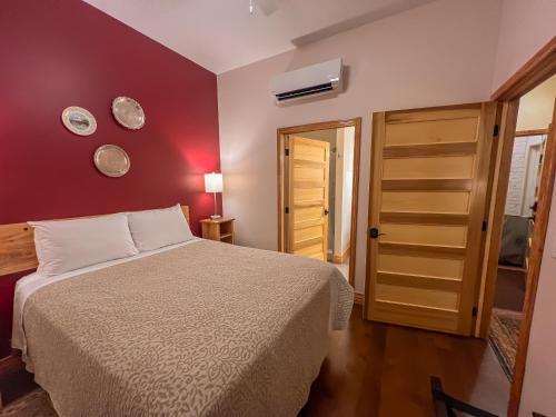 a bedroom with a bed and a red wall at Elkader Suites in Elkader