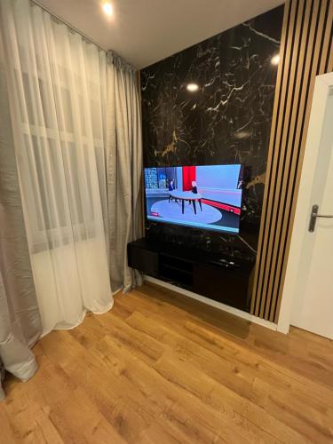 a living room with a tv and a wooden floor at ANETT Apartament nr 4 in Sulęcin