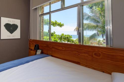 a bedroom with a bed and a window with a view at Studio Oceanview in Rio de Janeiro