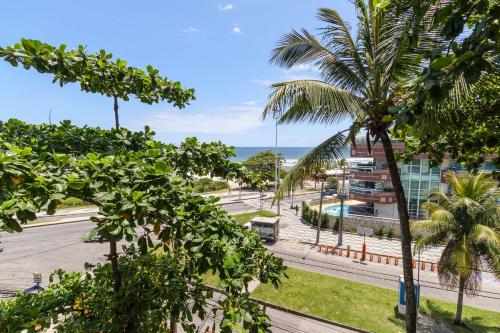 a view of a street with palm trees and the ocean at Studio Oceanview in Rio de Janeiro