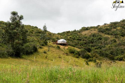 un edificio sul fianco di una collina di Skyline Glamping a Santuario