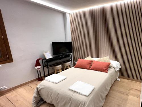 a bedroom with a bed with red pillows and a piano at Apartamentos Baladrias Formigal Centro - Recién Reformado in Formigal