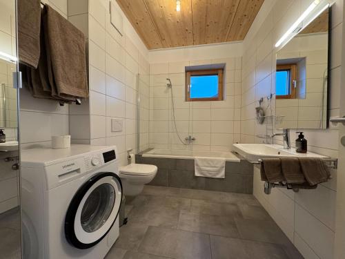 a bathroom with a washing machine and a sink at Gamsfels Balbina Galeriewohnung in Langen bei Bregenz