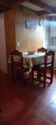 a table with two chairs and a table with a cloth on it at cabañas Cadiz in Valdivia