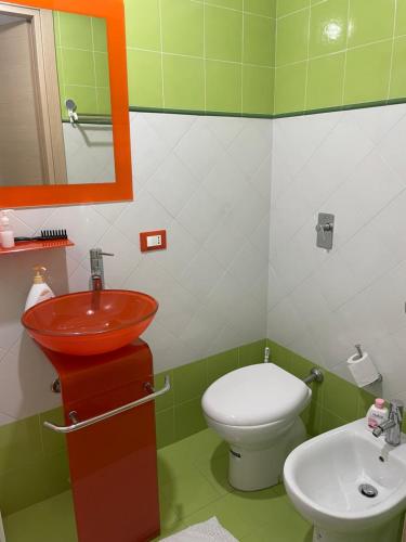 uma casa de banho verde e branca com um lavatório e um WC em Casa Frisella em Marsala