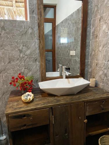 a bathroom with a white sink and a mirror at Waka Waka in Pwani Mchangani