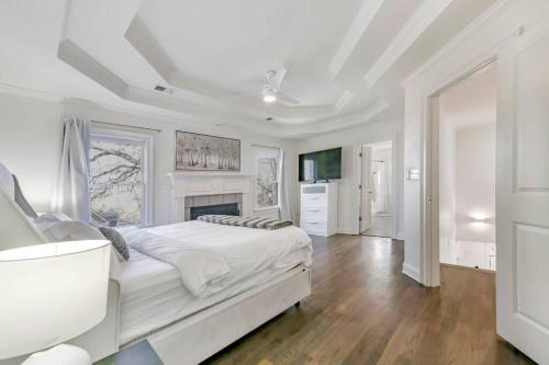 a white bedroom with a large bed and a fireplace at Amazing Location Spacious House in Atlanta