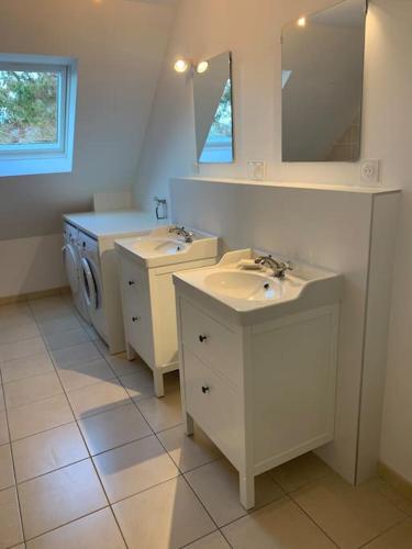 une salle de bain avec deux lavabos et une machine à laver dans l'établissement Villa les Agapanthes, à Carantec