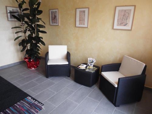 a waiting room with two chairs and a potted plant at B&B Il Portico in Praticello di Gattatico