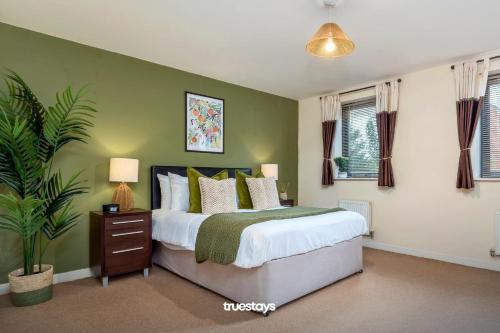 Un dormitorio con una cama y una planta. en NEW Greydawn House - Stunning 4 Bedroom House in Stoke-on-Trent en Stoke on Trent