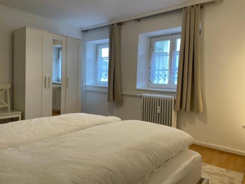 2 camas en una habitación con 2 ventanas en Wohnung mit 3 Schlafzimmern, Dachterrasse und Flussblick, en Ühlingen-Birkendorf