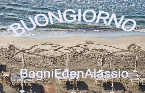 a beach with chairs and a sign that says bamboosarioarioarioario at Hotel Eden Alaxi Hotels in Alassio
