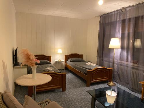 Habitación de hotel con 2 camas y mesa en Emotion en Vlotho