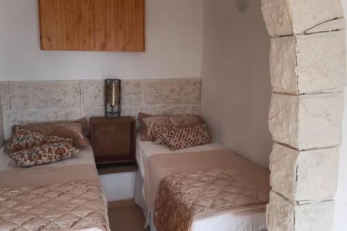 a room with two beds and a table with a lamp at Self-Contained Garden apartment with Galilee sea & mountains view 2 in Safed