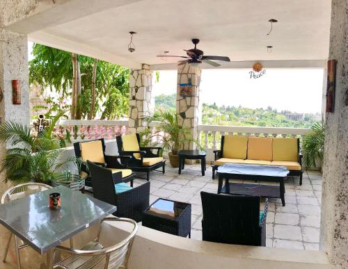 a patio with chairs and tables and a patio with a view at Les Residences Etang Du Jonc in Petionville