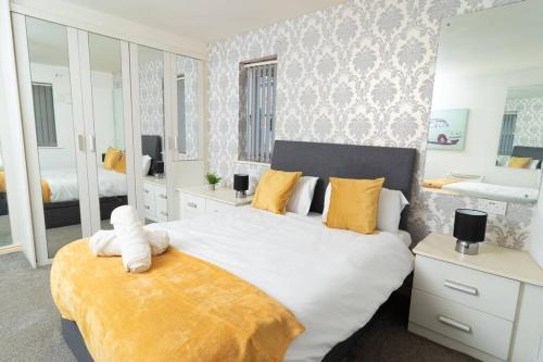 a bedroom with a large bed with a yellow blanket at Central Liverpool Gem 3 bedroom House Private Parking in Liverpool