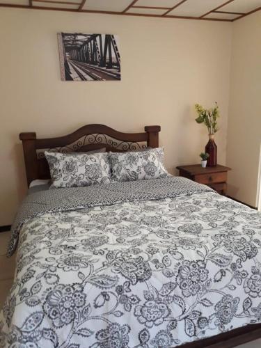 1 dormitorio con 1 cama con edredón azul y blanco en Kubo Home 4 Bedrooms 5 mins SJO Airport en Alajuela