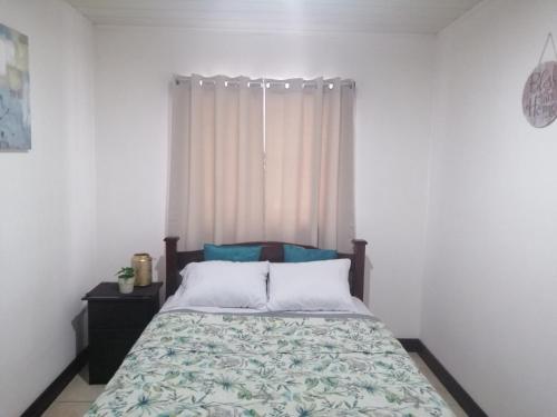 1 dormitorio con cama y ventana en Kubo Home 4 Bedrooms 5 mins SJO Airport en Alajuela