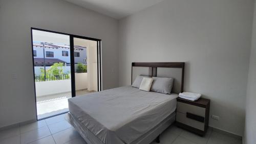 Un dormitorio con una cama y una ventana grande. en Casa en Residencial San Andrés, en San Miguel