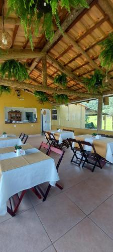a group of tables and chairs in a room at Pousada Mirante dos Ipês - Capitólio - MG in Capitólio