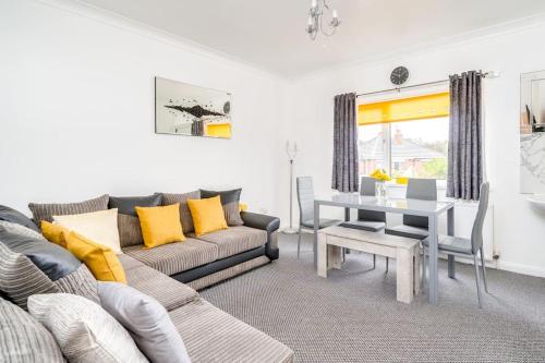 a living room with a couch and a table at Contemporary 5 Bedroom Flat in Killingbeck