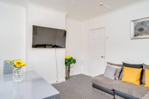 a living room with a couch and a table at Contemporary 5 Bedroom Flat in Killingbeck